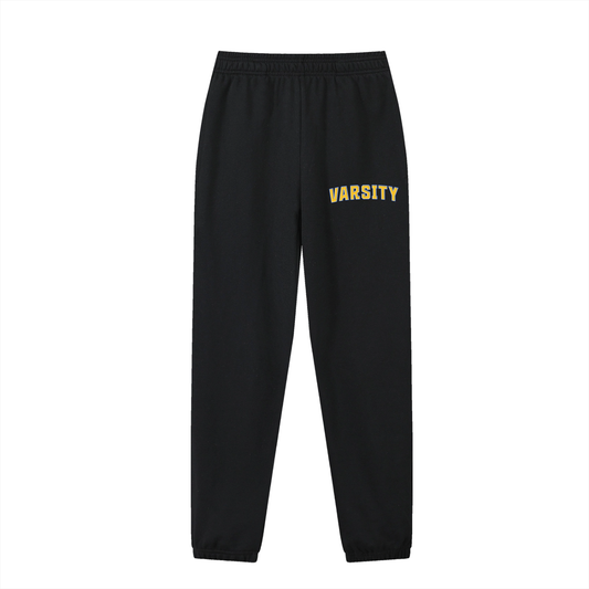 Black sweatpants with 'Varsity' text in yellow on a white background